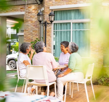 Residents engaged in conversation outdoors at a senior care facility