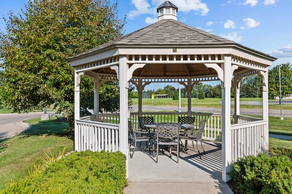 Outdoor gazebo with seating and greenery