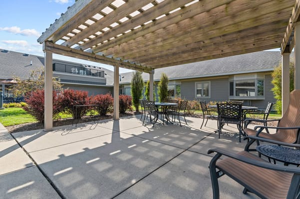Outdoor seating area under a pergola in a senior care facility