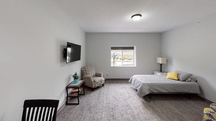 Cozy resident room with a bed and chair