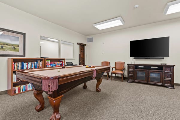 Interior recreation room with a pool table and seating