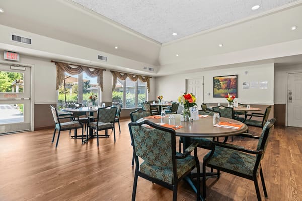 Dining area with tables and flowers in a senior living facility