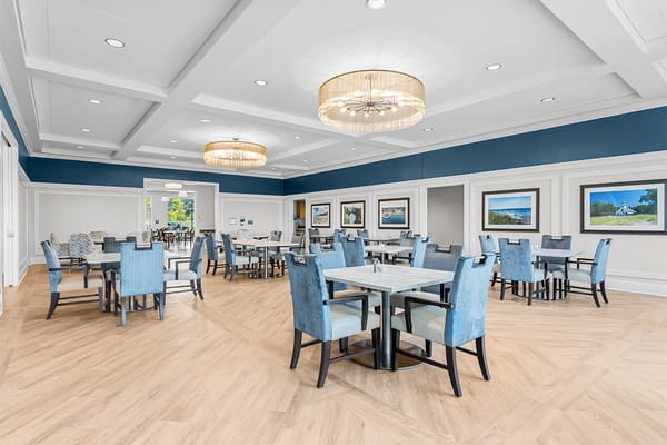 Bright dining room with blue chairs and table settings