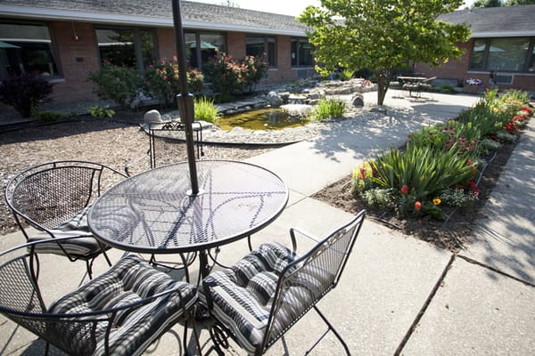 Outdoor seating area with a garden and pond