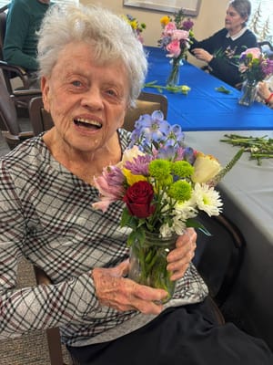 Resident holding a flower arrangement in a common area