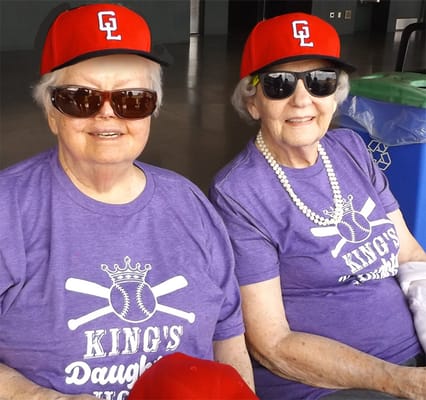 Two residents in matching shirts and hats