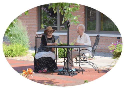 Two residents enjoying conversation at an outdoor table