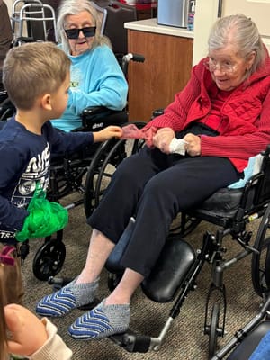 Two residents interacting with a child in a common area