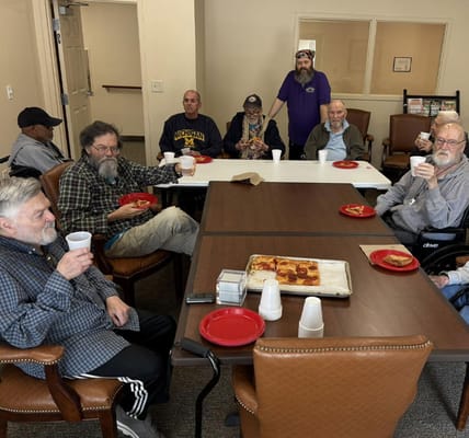 Residents enjoying pizza and drinks in a common area