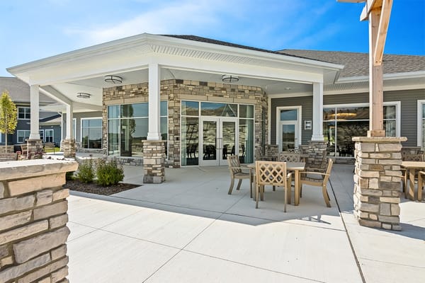 Exterior view of a senior living facility with outdoor seating