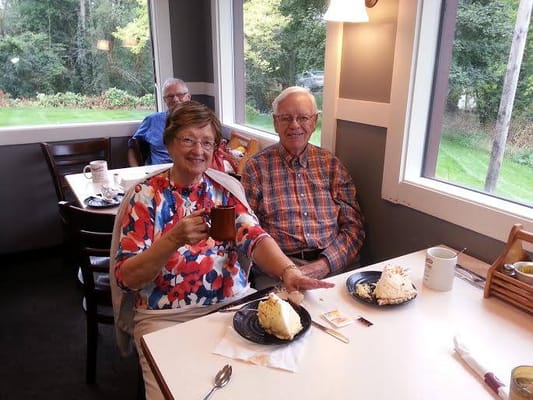 Two residents enjoying dessert and coffee in the dining area