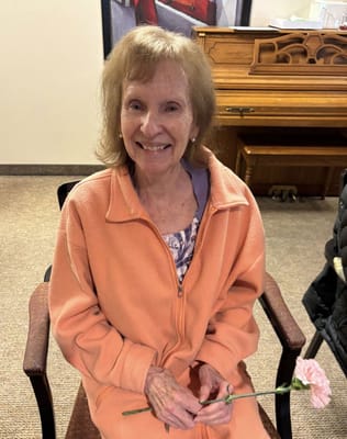 Resident in a common area holding a flower