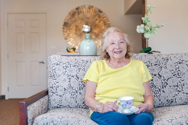 A smiling senior woman enjoying tea in a bright living space