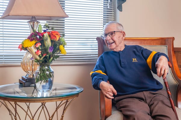 A resident smiling in a cozy interior setting