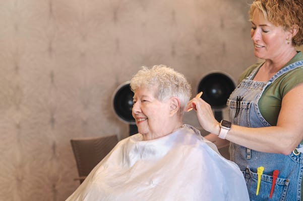 Staff member giving a haircut to a resident