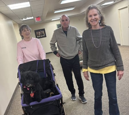 Residents enjoying a walk in the hallway with a dog