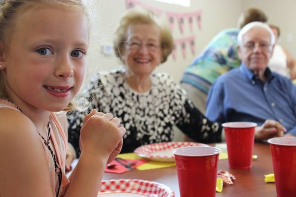 Residents and a child enjoying a meal together