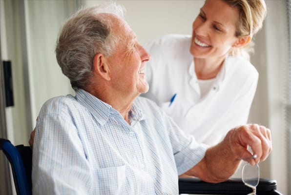 A caregiver smiling with a resident in a facility