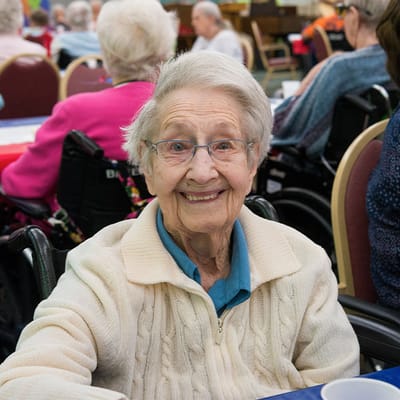 Smiling resident in a lively common area setting