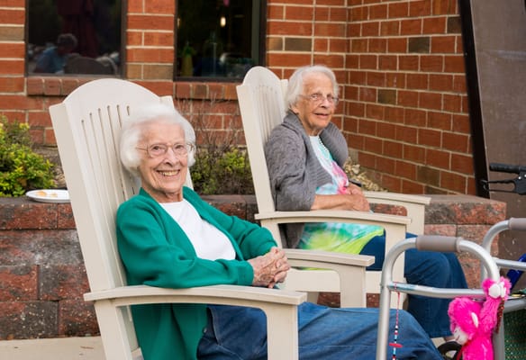 Two elderly women enjoying time outdoors in chairs