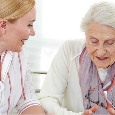 Care staff interacting with a resident in a bright room