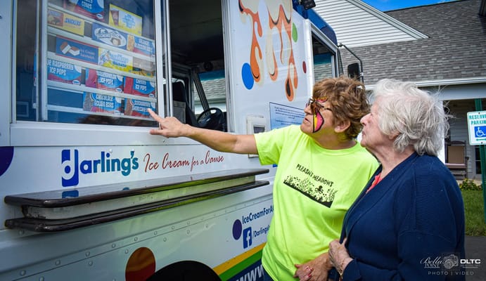 A resident enjoying ice cream with staff outside