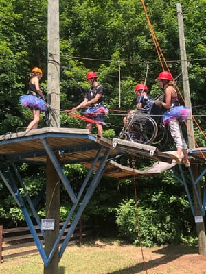 Residents participating in an outdoor activity on a ropes course