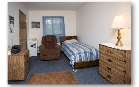 Cozy resident room with a bed and recliner