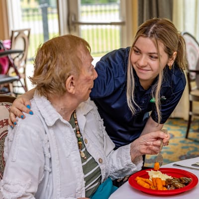 Staff assisting a resident during meal service