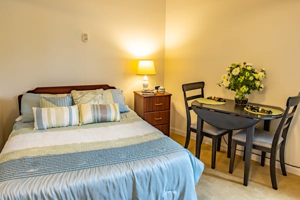 A cozy resident room with a bed and dining table