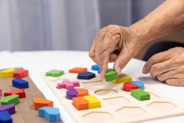 Close-up of a hand playing with colorful puzzle pieces