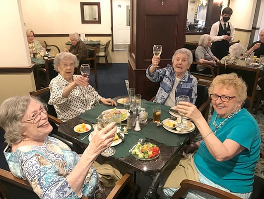 Residents raising glasses in a dining room celebration