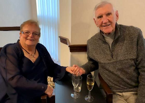 Two residents enjoying drinks together in a cozy setting