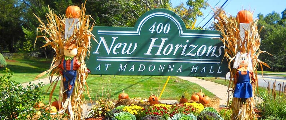Exterior sign of New Horizons at Madonna Hall decorated for fall