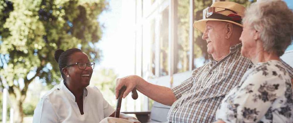 Residents enjoying time outdoors with staff assistance