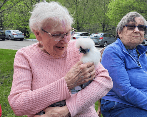 Residents interacting with a pet in a garden setting