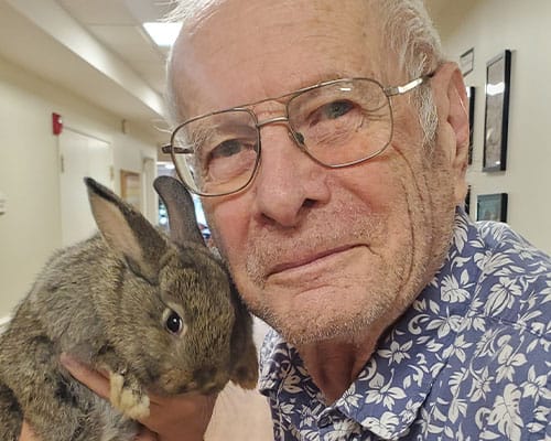 Resident holding a rabbit in a common area