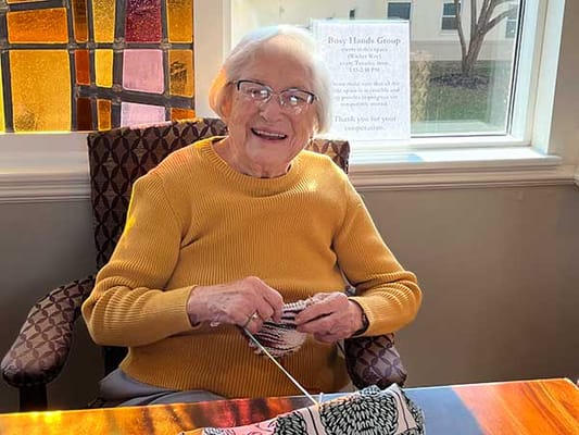 Resident engaging in a crafting activity in a sunny room