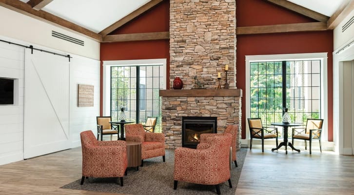 A cozy common area with seating and a stone fireplace