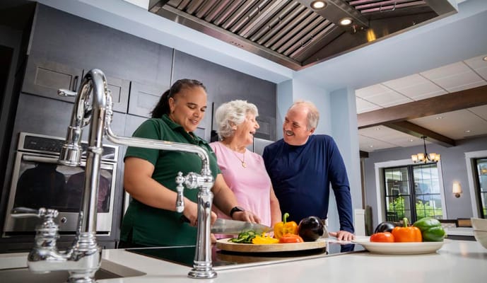Residents and staff cooking in a kitchen