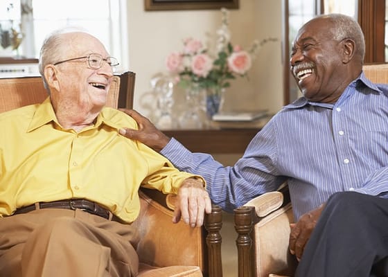 Two male residents sharing a joyful moment indoors