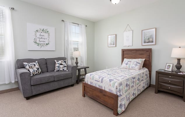 Cozy single resident room with a bed and seating area