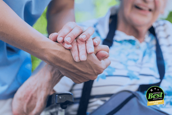 Caregiver holding hands with senior resident