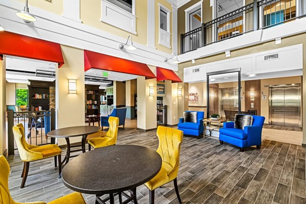 Bright common area with yellow chairs and blue sofas