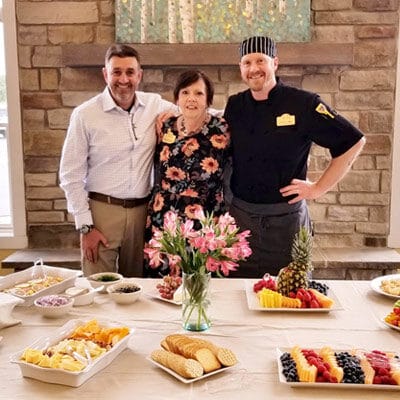 Residents and staff celebrating with a food spread