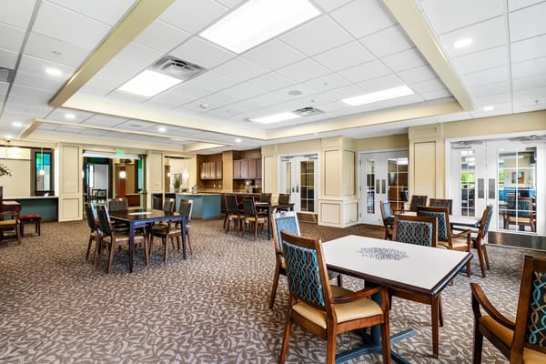 Bright common area with dining tables and kitchen access