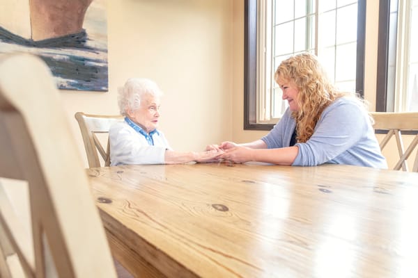Caregiver and resident in a warm indoor setting