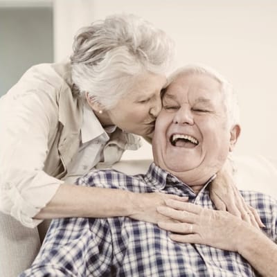 An elderly couple sharing a joyful moment indoors