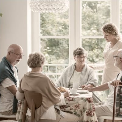Residents enjoying conversation over tea in a cozy setting
