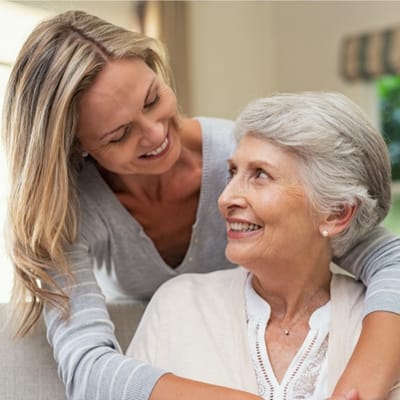 Caregiver smiling with a resident in a cozy interior